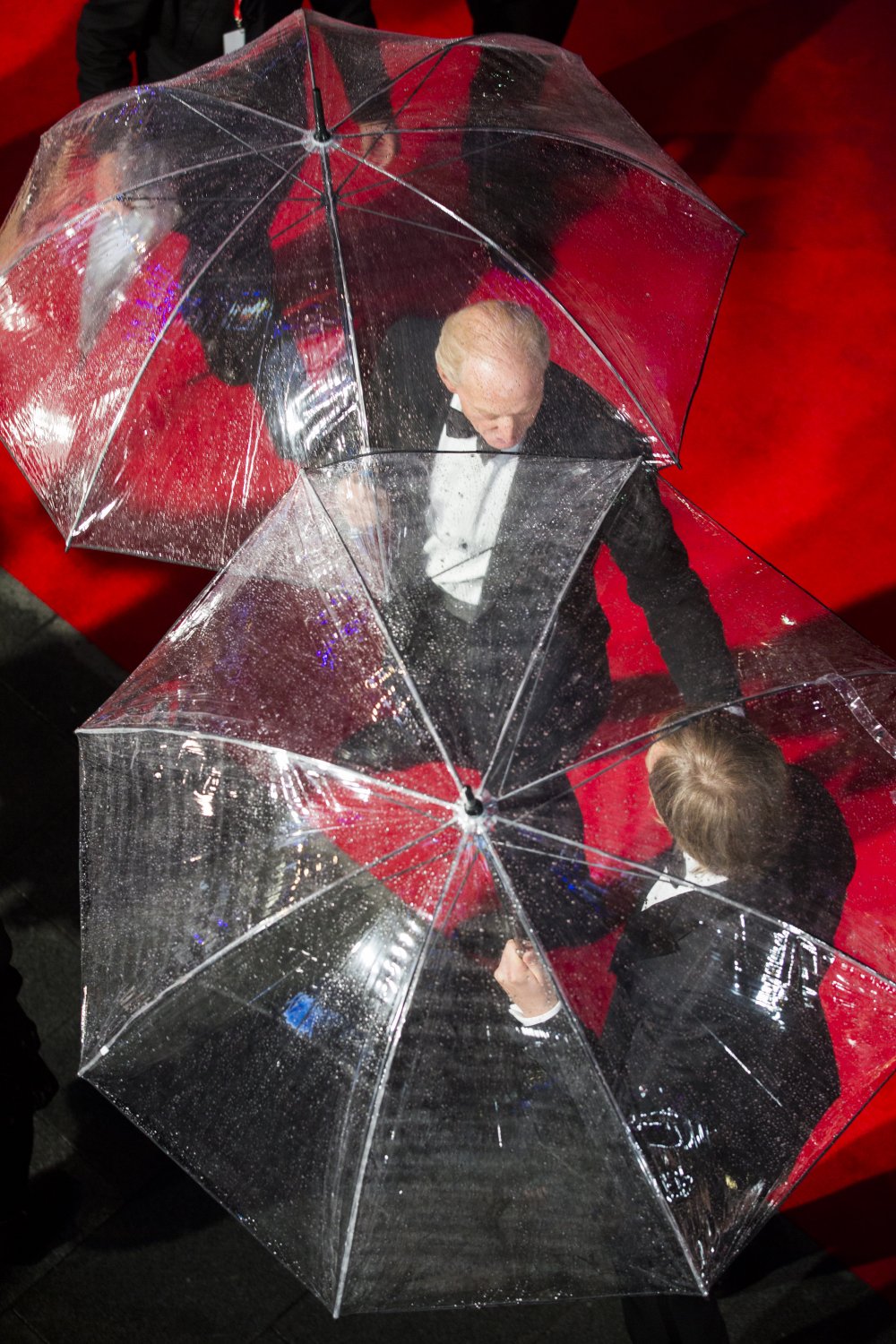 An overhead shot of Imitation Game co-star Charles Dance and director Morten Tyldum brandishing their umbrellas on the drizzly night of their film&amp;#8217;s premiere