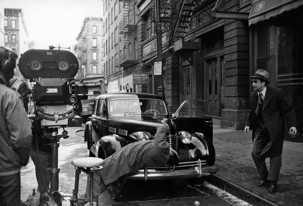 The crew films a street assassination stunt, with John Cazale as Fredo Corleone, the weak link in the Corleone family, watching helplessly from the curb