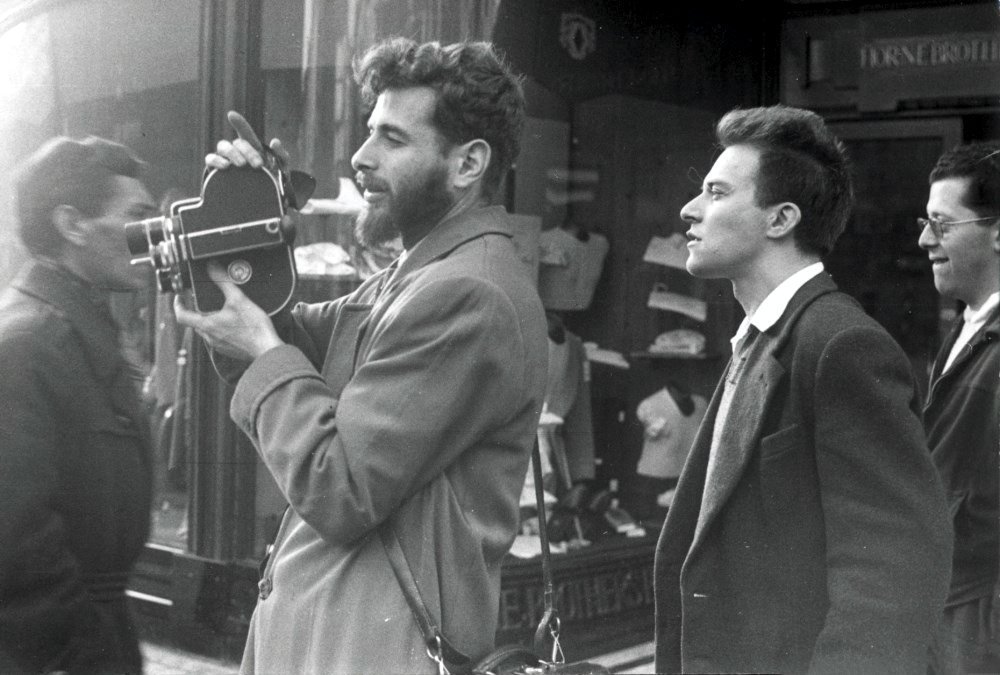 Walter Lassally with his 16mm Bolex camera shooting Refuge England (1949) with Robert Vas in London’s West End